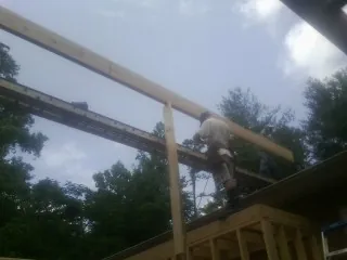 Carpenter setting a ridge beam over a new addition frame — Ice Dam Removal by Roofing Brothers in The Colony
