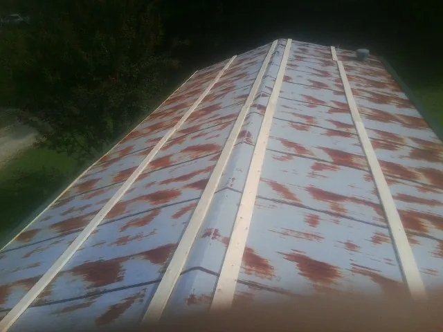 Rusted metal roof panels with new wood purlins before replacement — Storm Damage Roof Repair in The Colony by Roofing Brothers