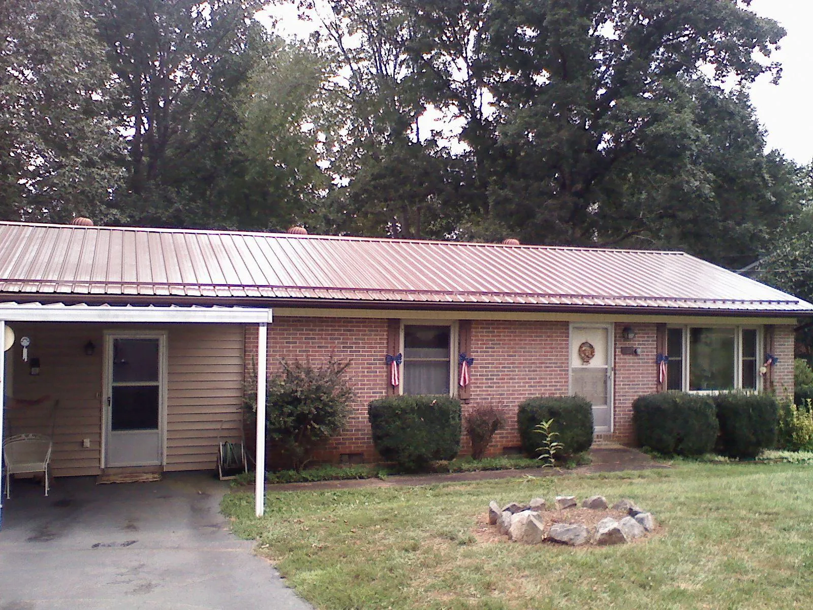 Bronze metal roof and carport on a brick ranch home — Roof Repair work by our crew in The Colony